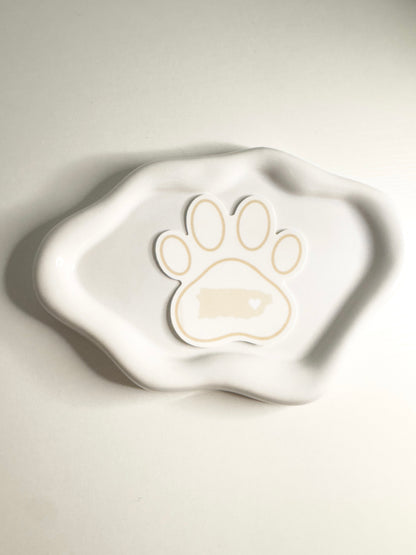 White ceramic dish with a paw print design  of Puerto Rico on a light gray background