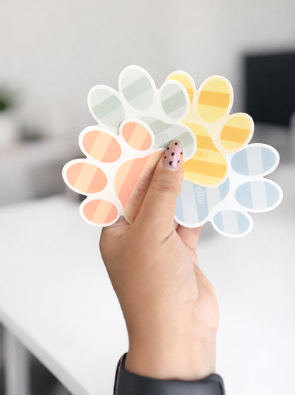 Hand holding a paw print-shaped color swatch palette with gradient colors.