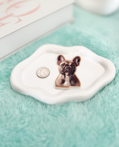 Dog-shaped jewelry dish on a light blue surface with a coin for scale.