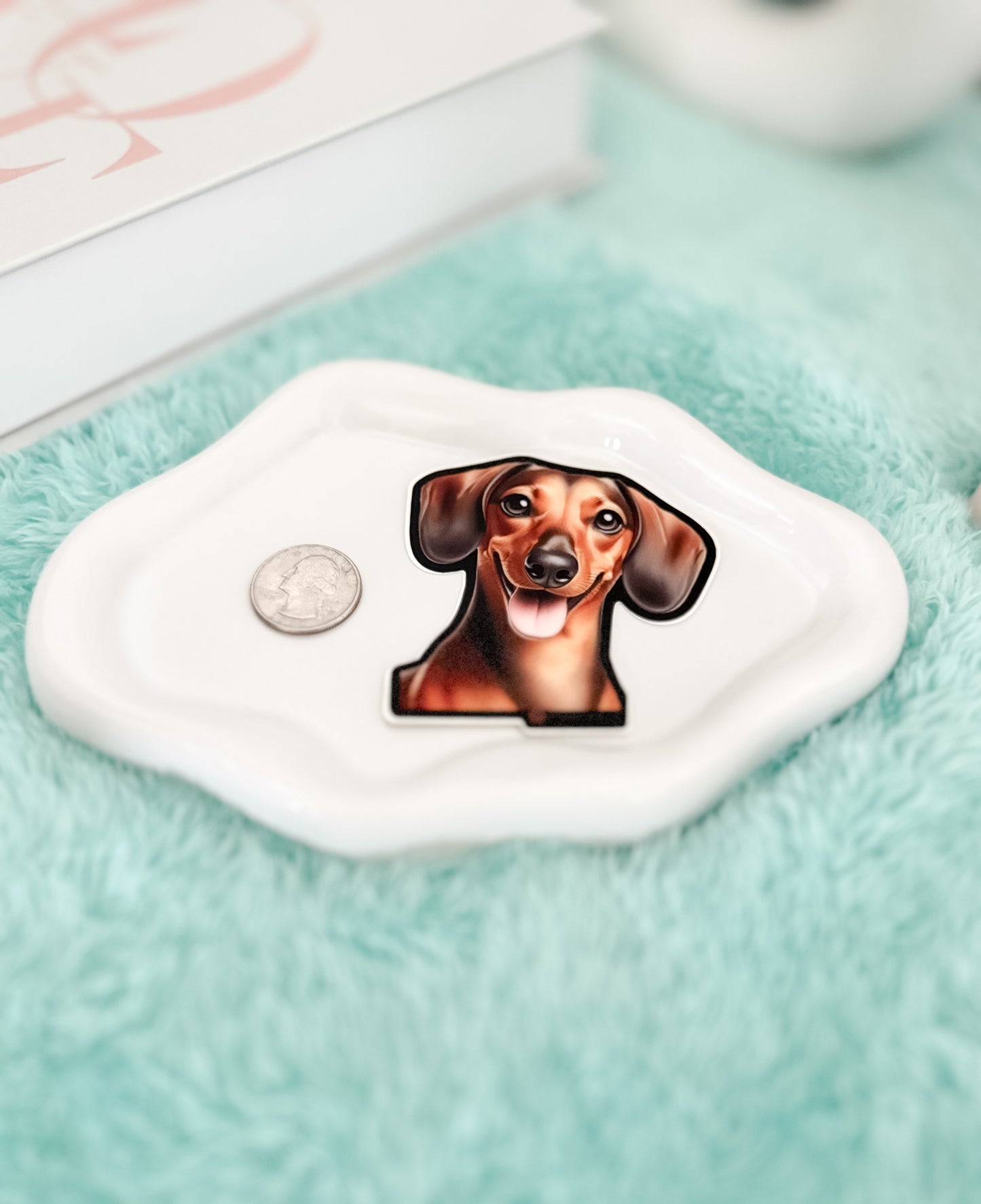 Small white dish with a dachshund design on a light blue surface