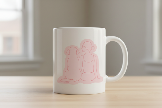 White mug with pink angel design on a wooden surface