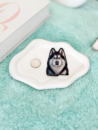 Small white dish with a dog illustration on a green surface