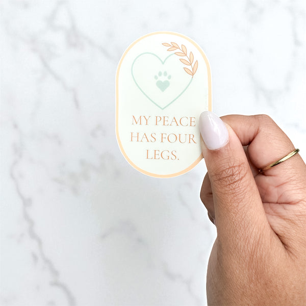 Minimalist vinyl sticker with a heart, paw, and botanical detail reading “My Peace Has Four Legs” — soft beige design, 1.99x3 inches.